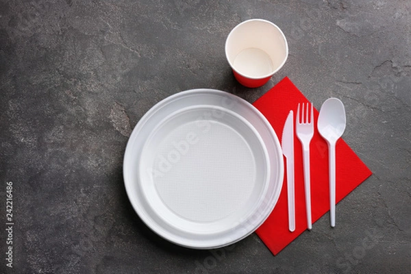 Fototapeta Composition with plastic dishware on grey background, flat lay. Picnic table setting