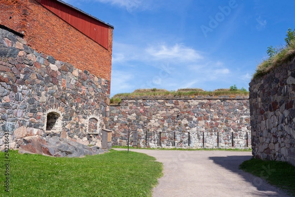 Fototapeta The old granite walls of the historic fortifications on Suomenlinna Forte Island are overgrown with grass in summer. Suomenlinna Island in the Gulf of Finland are tourist attractions.