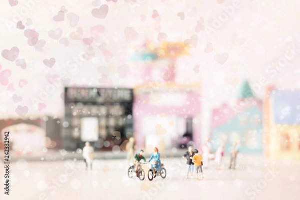 Fototapeta Happy young couple  (miniature) on cycle ride (miniature) on cycle ride in the city.Valentine's day background with selective focus and soft pastel color toned.