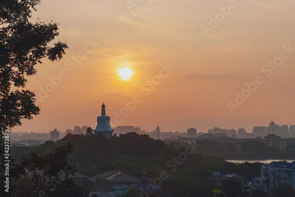 Fototapeta White Pagoda of Beihai Park against sunset, viewed from Jingshan Park, in Beijing, China