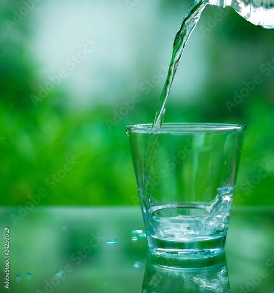 Fototapeta Drinking water in a glass on a wooden table