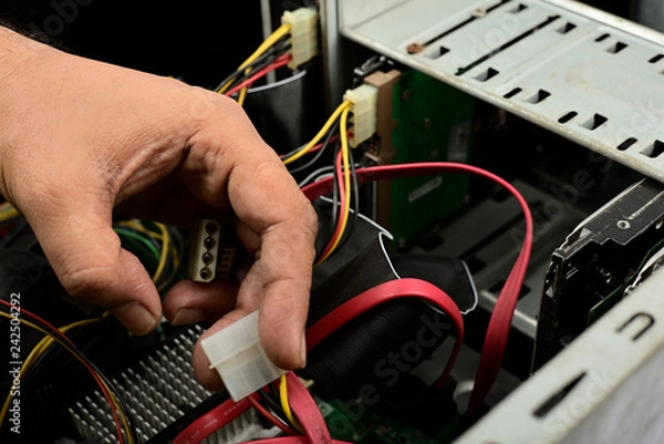 Fototapeta Engineer is repairing electric wire computer hardware in a computer CPU