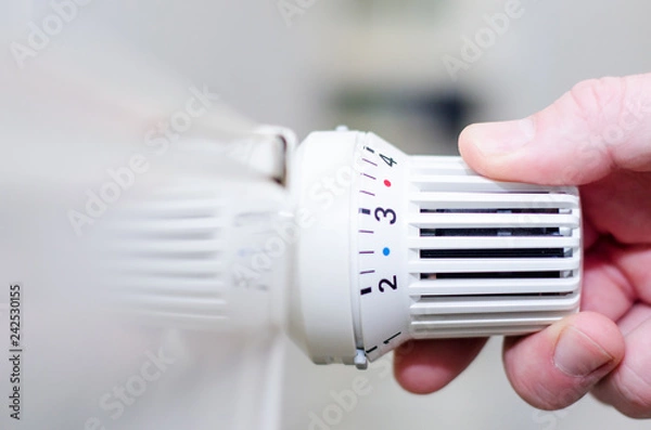 Obraz Close Up Of Hand Adjusting Heating Thermostat.