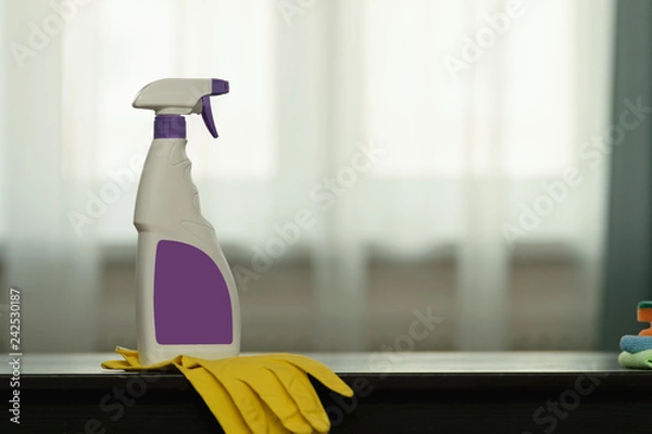 Fototapeta cleaning fluid with rubber gloves lying on the table in the house