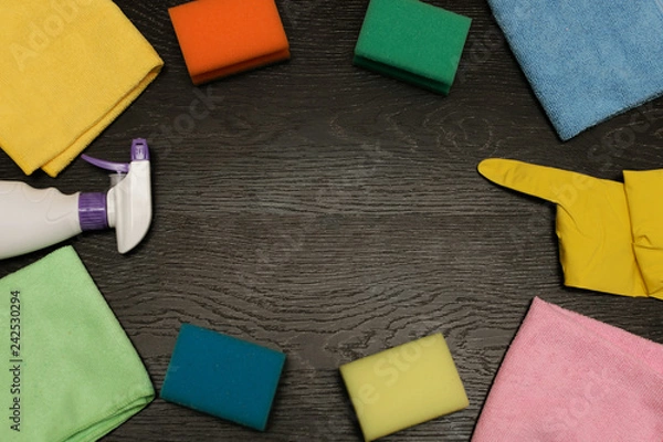 Obraz goods for cleaning the house, cleaning liquid with rubber gloves rags and sponges on wooden background, copy space.