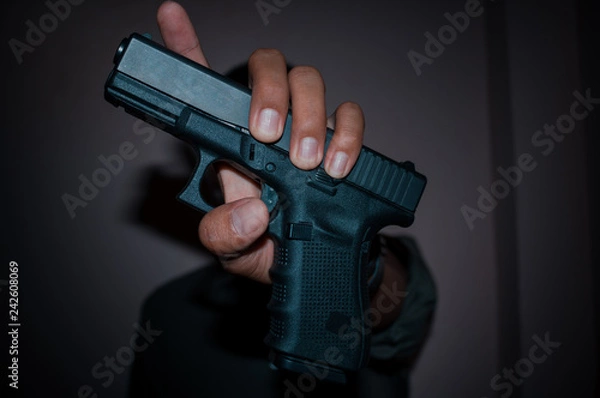 Obraz A man holding  gun in hand, the ship ready to shoot.A man is killer.