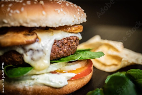 Fototapeta Hamburger vegetarian burger with falafel and vegetables salad tomato champignon and cheese tofu cheese all vegan food with nachos in blurred background