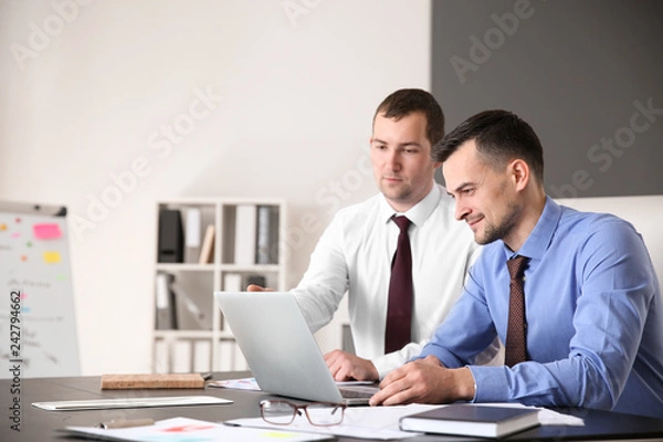 Fototapeta Young colleagues working together in modern office