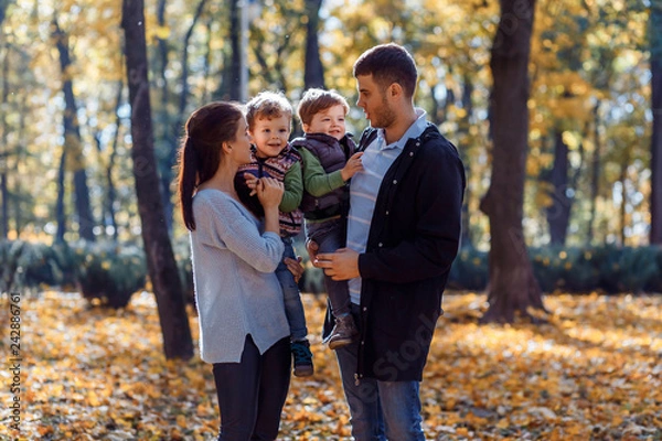 Obraz Natural pictures of a happy family of four having fun outsiade on a sunny autumn day. Togetherness and happiness concept