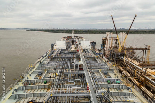 Fototapeta Tankowiec produktów naftowych wyładowywany na nabrzeże w porcie Baton Rouge.