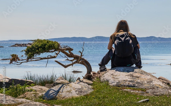 Fototapeta Girl sitting and looking at the ocean in the small island of Hallands Väderö in southern Sweden. 