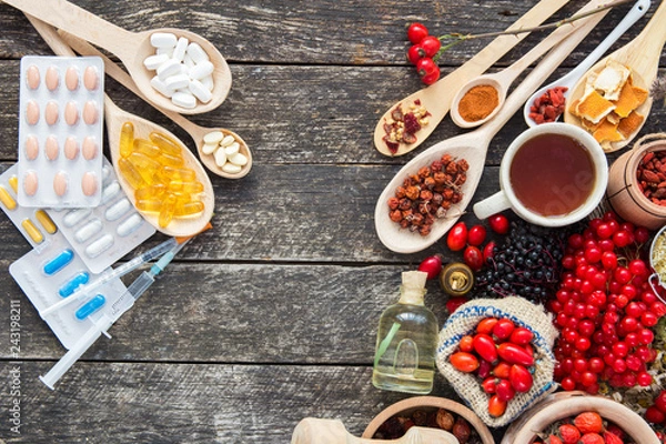 Fototapeta Medicinal tablets and pills and herbs composition: Dog rose, bunch branch Rosehips, types Rosa canina hips, essential oil. bunch, dried flowers of linden and chamomile elderberries and goji berries. 
