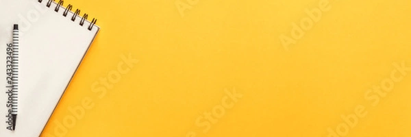 Obraz Blank yellow background with place for text. Copy space. Sketchbook and felt-tip pen as a decoration. Panoramic view from above. Flat lay, real photo. Minimal composition
