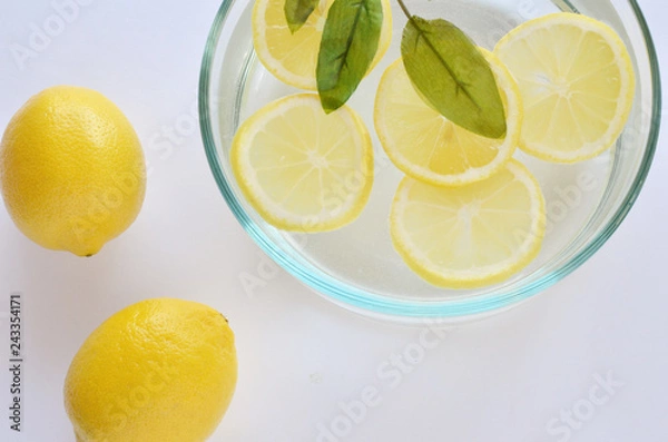 Fototapeta White background with lemons and lemon slices flatlay for skincare regime.