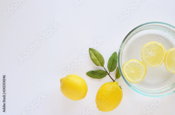 Fototapeta White background with lemons and lemon slices flatlay for skincare regime.