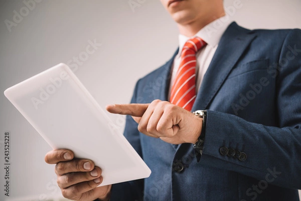 Fototapeta cropped view of businessman using digital tablet isolated on grey
