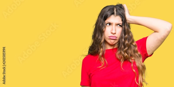 Fototapeta Young beautiful woman wearing casual t-shirt confuse and wonder about question. Uncertain with doubt, thinking with hand on head. Pensive concept.