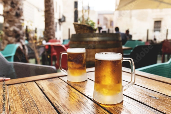 Fototapeta Ice cold inviting beer for two for refreshing the summer heat at the bar table