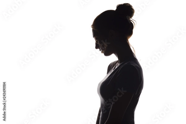 Fototapeta profile silhouette of a pensive girl, a young woman lowered her head down on a white isolated background