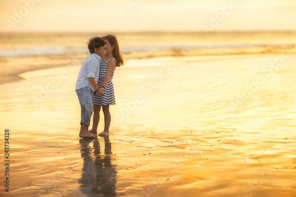 Obraz girl whispering to boy standing on the beach