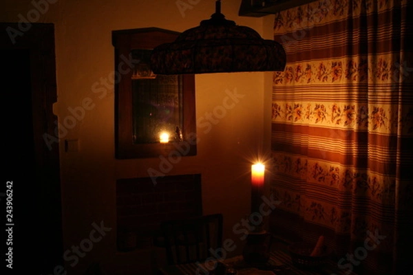 Fototapeta Room corner with char tavle mirrow lit up by candle flame