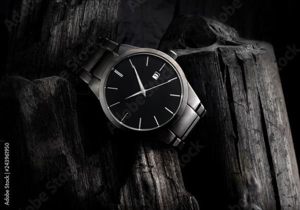 Fototapeta Luxury black metal wristwatch, on top of a pile of coal, with lots of contrast and texture