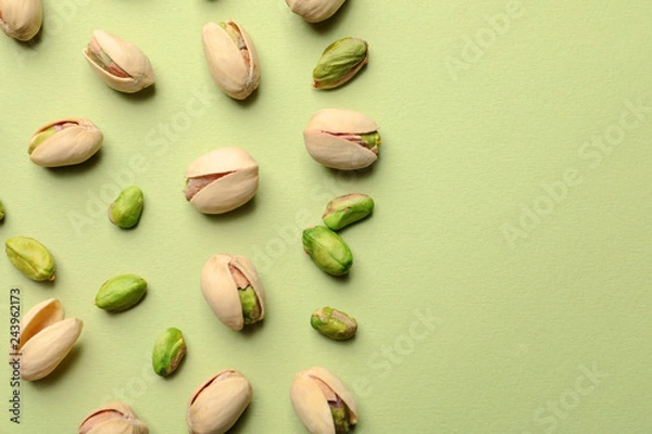 Obraz Organiczne orzechy pistacjowe na kolorowym tle, flat lay. Miejsce na tekst