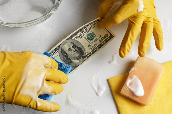 Obraz Laundering of money. A man in gloves washes a hundred dollars.