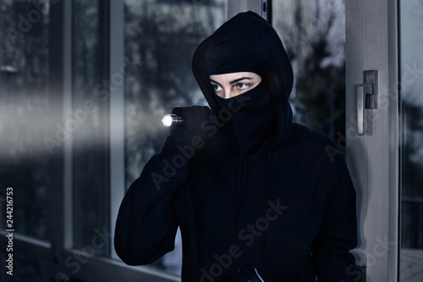Obraz Einbrecher mit Taschenlampe in Wohnung 