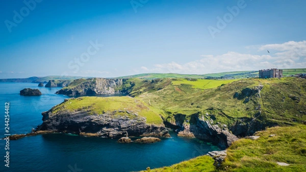Fototapeta Merlin's Cave, green rocky cliffs, dramatic landscape with Atlantic Ocean / Celtic Sea view from Tintagel castle island in Cornwall, United Kingdom, UK. Western England coastline summer holidays.