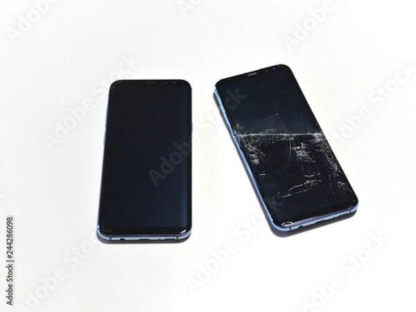 Fototapeta Two identical smartphones, one of which is broken. The screen of the smartphone is broken.