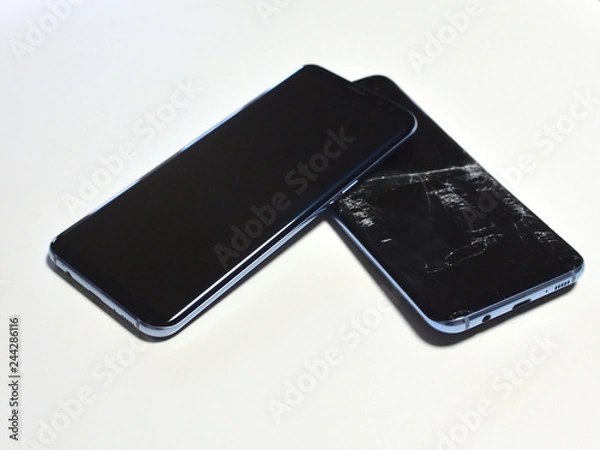 Fototapeta Two identical smartphones, one of which is broken. The screen of the smartphone is broken.