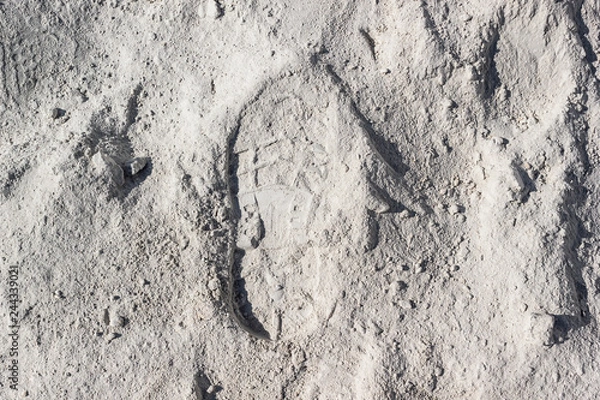 Fototapeta Footprint on white sand or dust. The trail of man on lunar soil or desert.