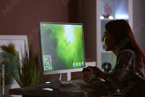Fototapeta Beautiful young woman playing computer game at home