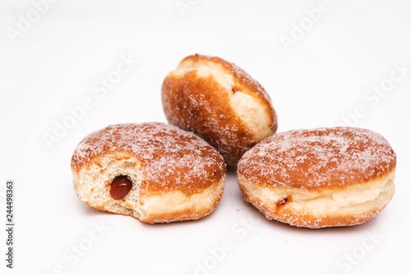 Fototapeta Traditional German or Austrian fried donuts with no hole, so called Krapfen, Berliner or Pfannkuchen with cinnamon sugar and filled with rose hip, raspberry or strawberry jam, party or carnival food