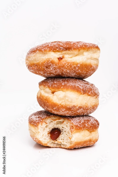 Fototapeta Traditional German or Austrian fried donuts with no hole, so called Krapfen, Berliner or Pfannkuchen with cinnamon sugar and filled with rose hip, raspberry or strawberry jam, party or carnival food