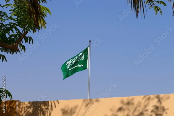 Fototapeta The flag of the Kingdom of Saudi Arabia waving in the historic Diriyah