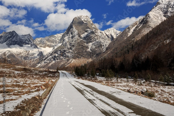 Fototapeta ShuangQiao Valley Scenic Area, Four Girls Mountain National Park in Sichuan Province China. Snow Capped Jagged Mountains and Blue Sky, Snow Mountains, Empty National Park Utility Access Road