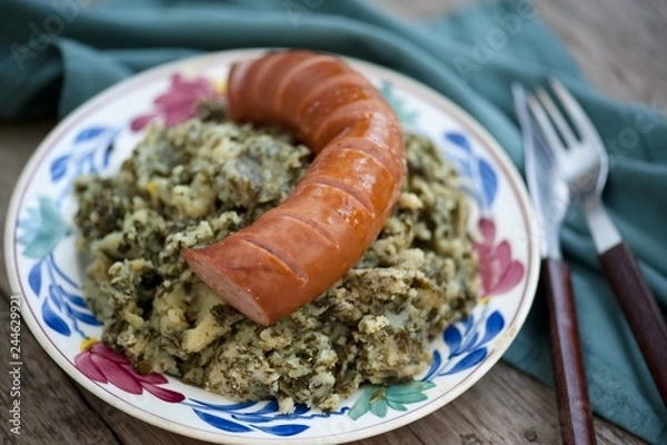Fototapeta Rustic cuisine with “Boerenkool spamppot” or smoked sausage cabbage, traditional Dutch food. With a typical Dutch plate. stamppot boerenkool .