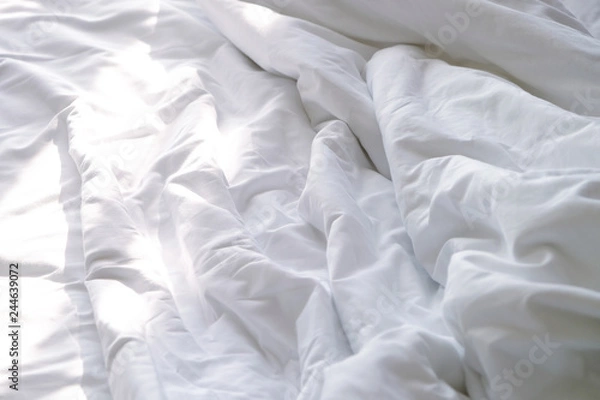 Obraz Top view of white unmade bedsheet on a bed in bedroom with beautiful sunlight