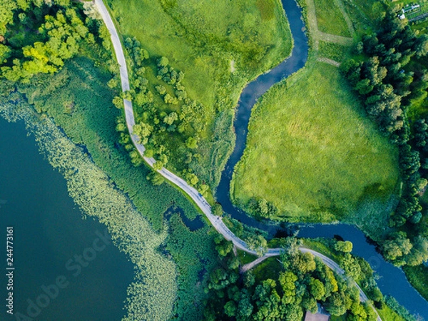 Fototapeta Aerial Photo of Car Driving on the Road going by the River under the Trees, Top Down View in Early Spring on Sunny Day