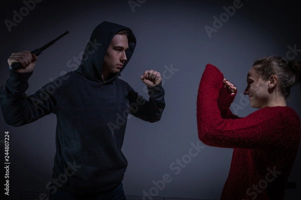 Obraz Mann attackiert eine Frau mit einem Schlagstock