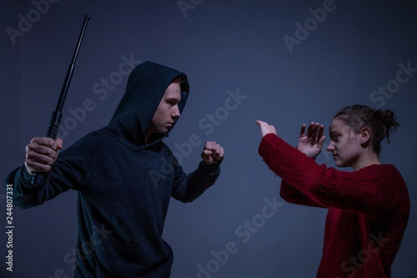 Obraz Mann attackiert eine Frau mit einem Schlagstock