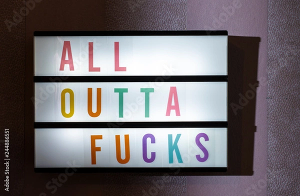 Fototapeta Message All Outta Fucks on illuminated board. Careless and empathy concept with text.