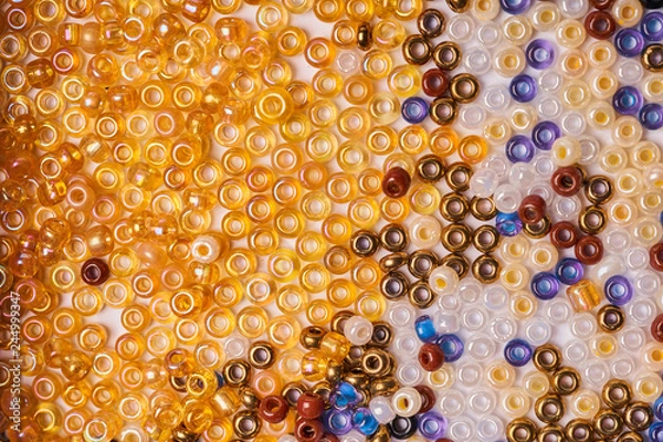 Fototapeta Multi-colored glass seed beads on a white background