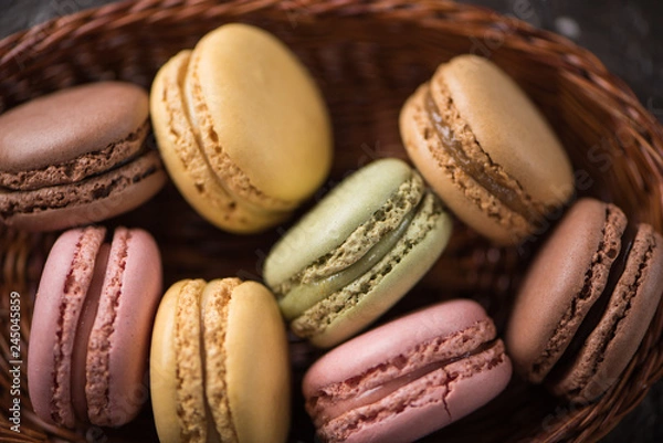 Fototapeta Top close view macaroons on wicker basket background