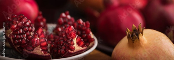 Fototapeta Cuted fresh pomegranate fruits on rustic background. banner maket. selective focus