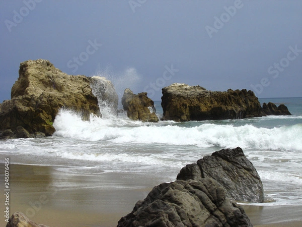 Obraz Ocean waves hitting rocks with a splash 