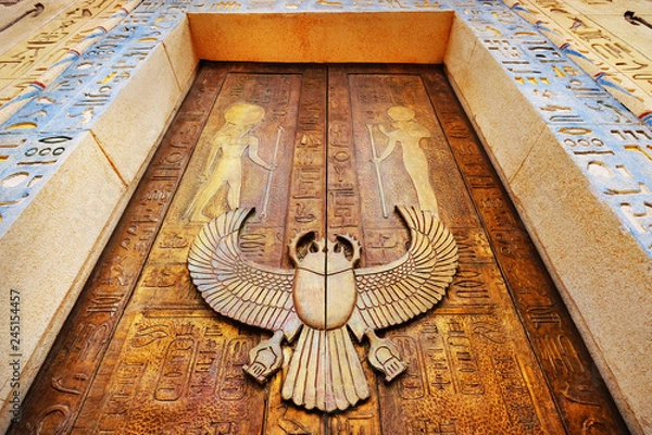 Fototapeta Ancient egypt scene. Hieroglyphic carvings on the exterior walls of an ancient egyptian temple.