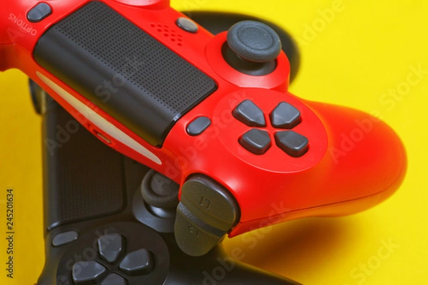 Fototapeta Fragment of buttons of two gamepad on a yellow background close-up.